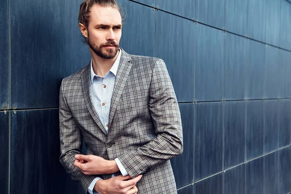 Portrait of sexy handsome fashion male model man dressed in elegant checkered suit posing outdoors on the street background — Stock Photo, Image