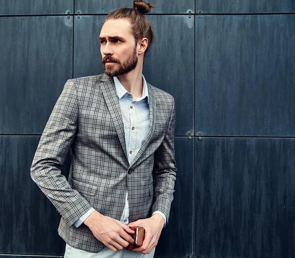 Retrato de sexy guapo hombre modelo masculino vestido con elegante traje a cuadros posando al aire libre en el fondo de la calle — Foto de Stock