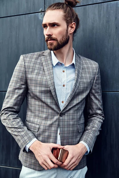 Ritratto di sexy bello moda maschio modello uomo vestito in elegante abito a scacchi posa all'aperto sullo sfondo della strada — Foto Stock