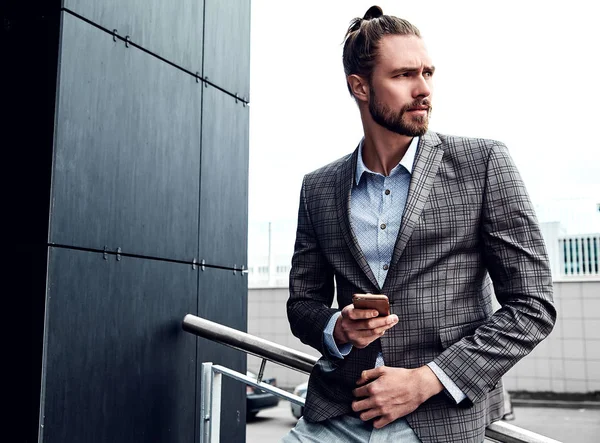 Portrait of sexy handsome fashion male model man dressed in elegant checkered suit posing outdoors on the street background — Stock Photo, Image