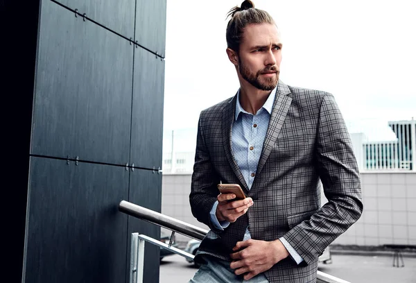 Portrait of sexy handsome fashion male model man dressed in elegant checkered suit posing outdoors on the street background — Stock Photo, Image