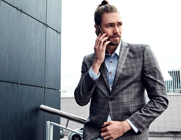 Portrait of sexy handsome fashion male model man dressed in elegant checkered suit posing outdoors on the street background — Stock Photo, Image