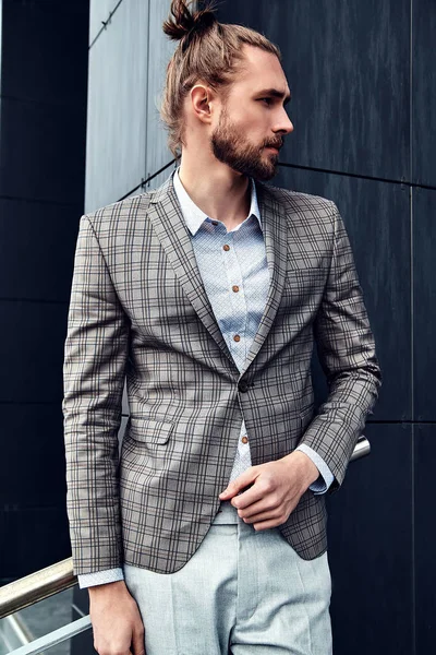 Portrait of sexy handsome fashion male model man dressed in elegant checkered suit posing outdoors on the street background — Stock Photo, Image