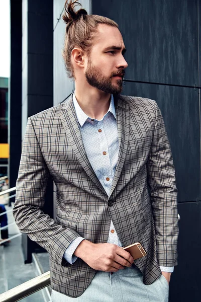 Portrait of sexy handsome fashion male model man dressed in elegant checkered suit posing outdoors on the street background — Stock Photo, Image