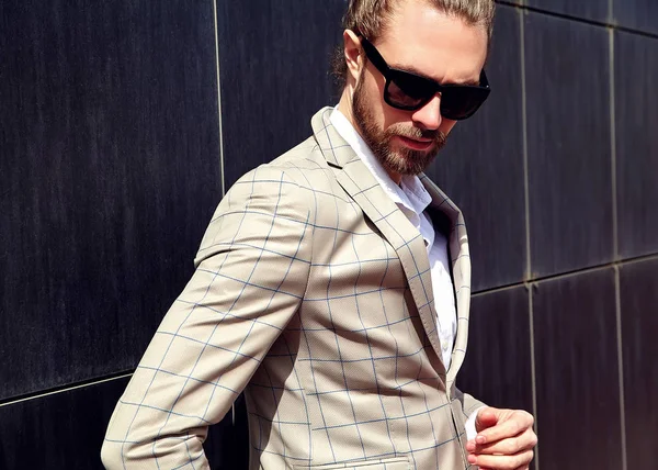 Portrait of sexy handsome fashion male model man dressed in elegant checkered suit posing outdoors on the street background — Stock Photo, Image