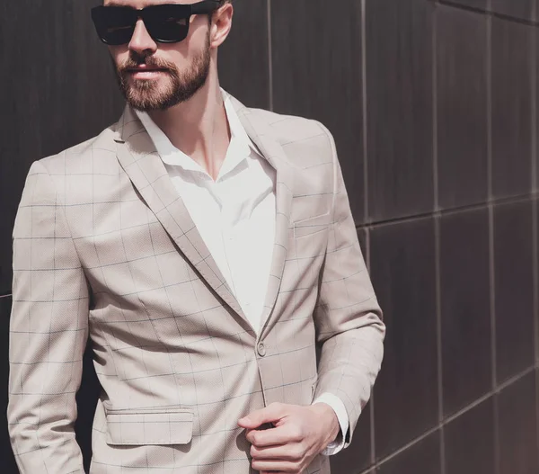 Portrait of sexy handsome fashion male model man dressed in elegant checkered suit posing outdoors on the street background — Stock Photo, Image