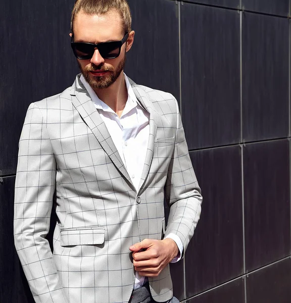 Retrato de sexy guapo hombre modelo masculino vestido con elegante traje a cuadros posando al aire libre en el fondo de la calle —  Fotos de Stock