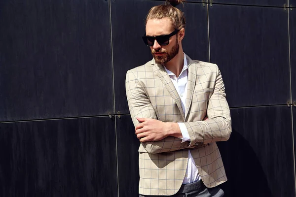 Portrait of sexy handsome fashion male model man dressed in elegant checkered suit posing outdoors on the street background — Stock Photo, Image