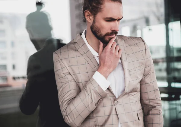 Portrait of sexy handsome fashion male model man dressed in elegant checkered suit posing outdoors on the street background — Stock Photo, Image