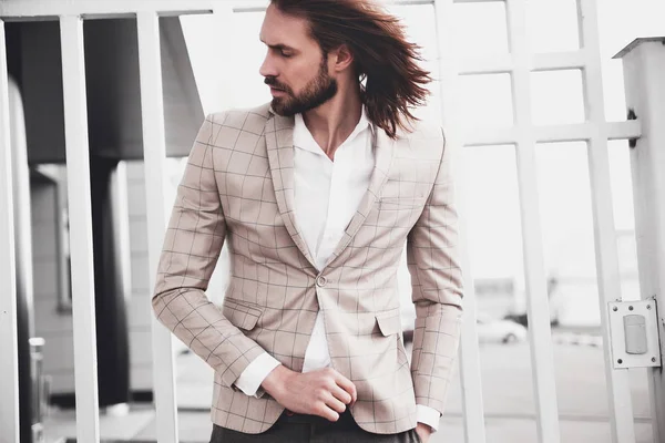 Portrait of sexy handsome fashion male model man dressed in elegant checkered suit posing outdoors on the street background — Stock Photo, Image