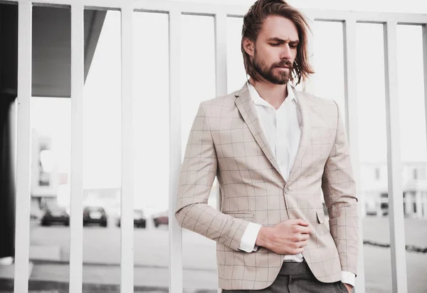 Retrato de sexy guapo hombre modelo masculino vestido con elegante traje a cuadros posando al aire libre en el fondo de la calle — Foto de Stock