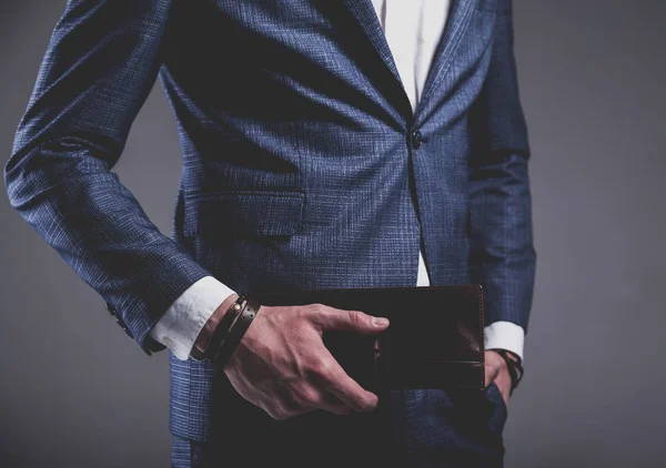 Jonge zakenman knap model man gekleed in elegante blauwe pak met toebehoren op handen — Stockfoto