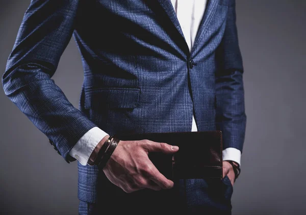 Joven hombre de negocios guapo modelo hombre vestido con elegante traje azul con accesorios en las manos —  Fotos de Stock