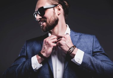 ellerinde aksesuarlarla zarif mavi elbiseli giyinmiş genç işadamı yakışıklı modeli adam 