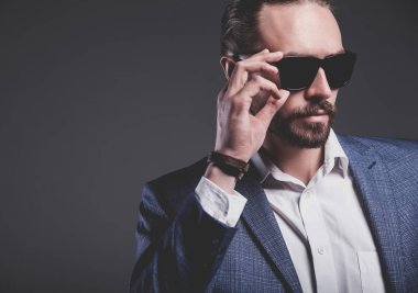 yakışıklı moda şık hipster işadamı modeli gri arka plan üzerinde poz zarif Mavi takım elbise giymiş