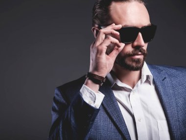 yakışıklı moda şık hipster işadamı modeli gri arka plan üzerinde poz zarif Mavi takım elbise giymiş