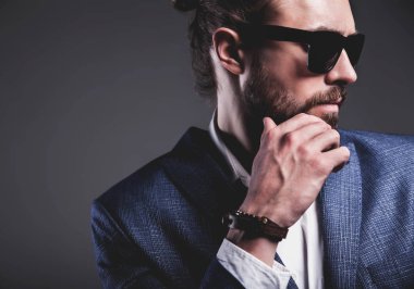 yakışıklı moda şık hipster işadamı modeli gri arka plan üzerinde poz zarif Mavi takım elbise giymiş