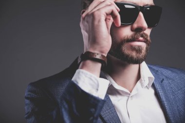 yakışıklı moda şık hipster işadamı modeli gri arka plan üzerinde poz zarif Mavi takım elbise giymiş