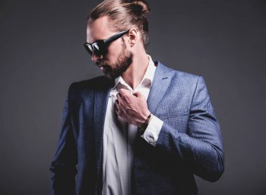 yakışıklı moda şık hipster işadamı modeli gri arka plan üzerinde poz zarif Mavi takım elbise giymiş