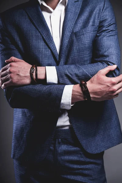 Jovem empresário bonito modelo homem vestido com elegante terno azul com acessórios a mãos — Fotografia de Stock