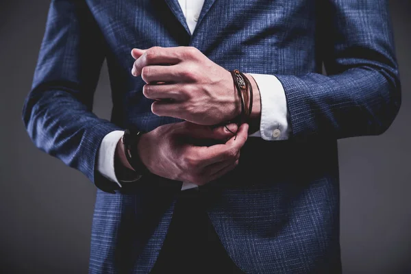 Jovem empresário bonito modelo homem vestido com elegante terno azul com acessórios a mãos — Fotografia de Stock