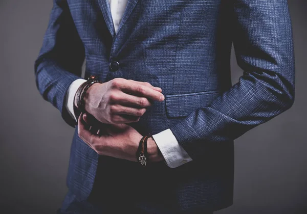 Joven hombre de negocios guapo modelo hombre vestido con elegante traje azul con accesorios en las manos —  Fotos de Stock