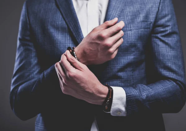 Joven hombre de negocios guapo modelo hombre vestido con elegante traje azul con accesorios en las manos — Foto de Stock
