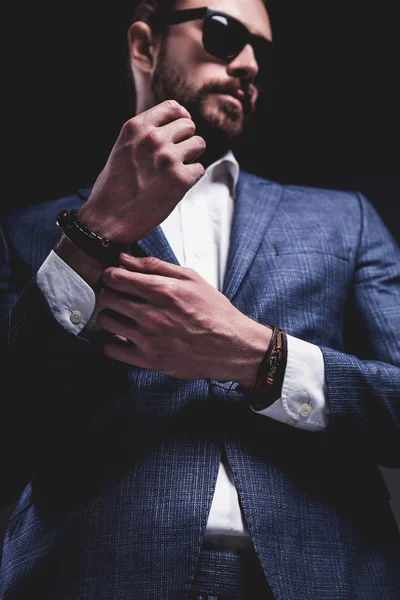 young businessman handsome model man dressed in elegant blue suit with accessories on hands