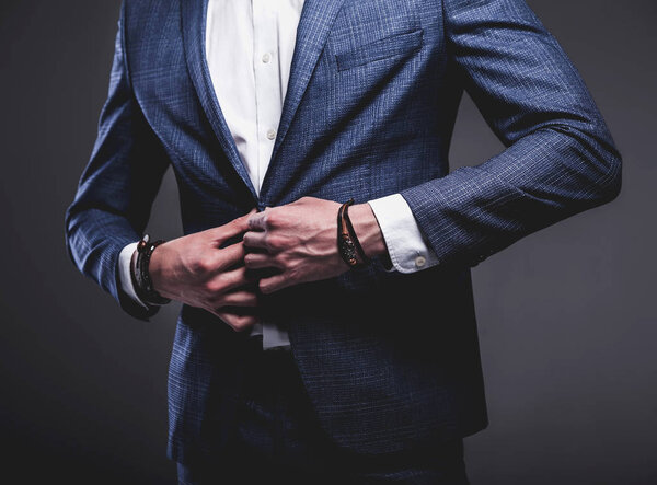 young businessman handsome model man dressed in elegant blue suit with accessories on hands 