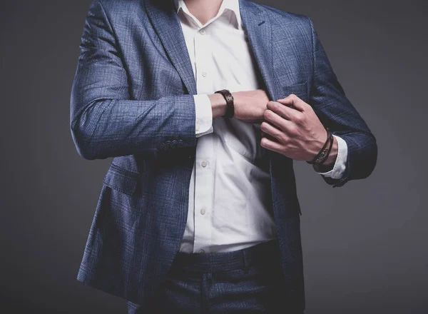 Joven hombre de negocios guapo modelo hombre vestido con elegante traje azul con accesorios en las manos —  Fotos de Stock