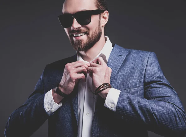 Joven hombre de negocios guapo modelo hombre vestido con elegante traje azul con accesorios en las manos —  Fotos de Stock