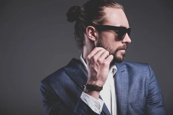 Hübsche Mode stilvolles Hipster-Geschäftsmann-Modell in elegantem blauen Anzug posiert auf grauem Hintergrund — Stockfoto