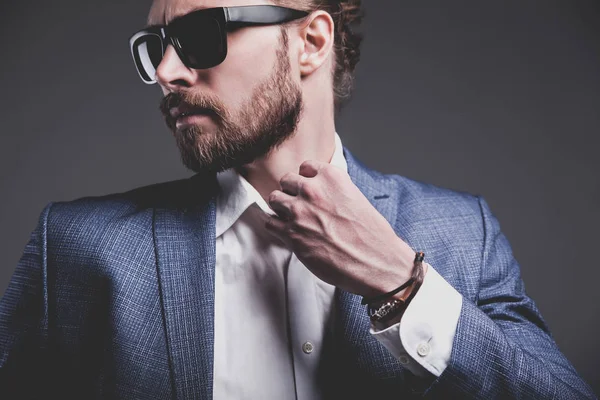 Handsome fashion stylish hipster businessman model dressed in elegant blue suit posing on gray background — Stock Photo, Image