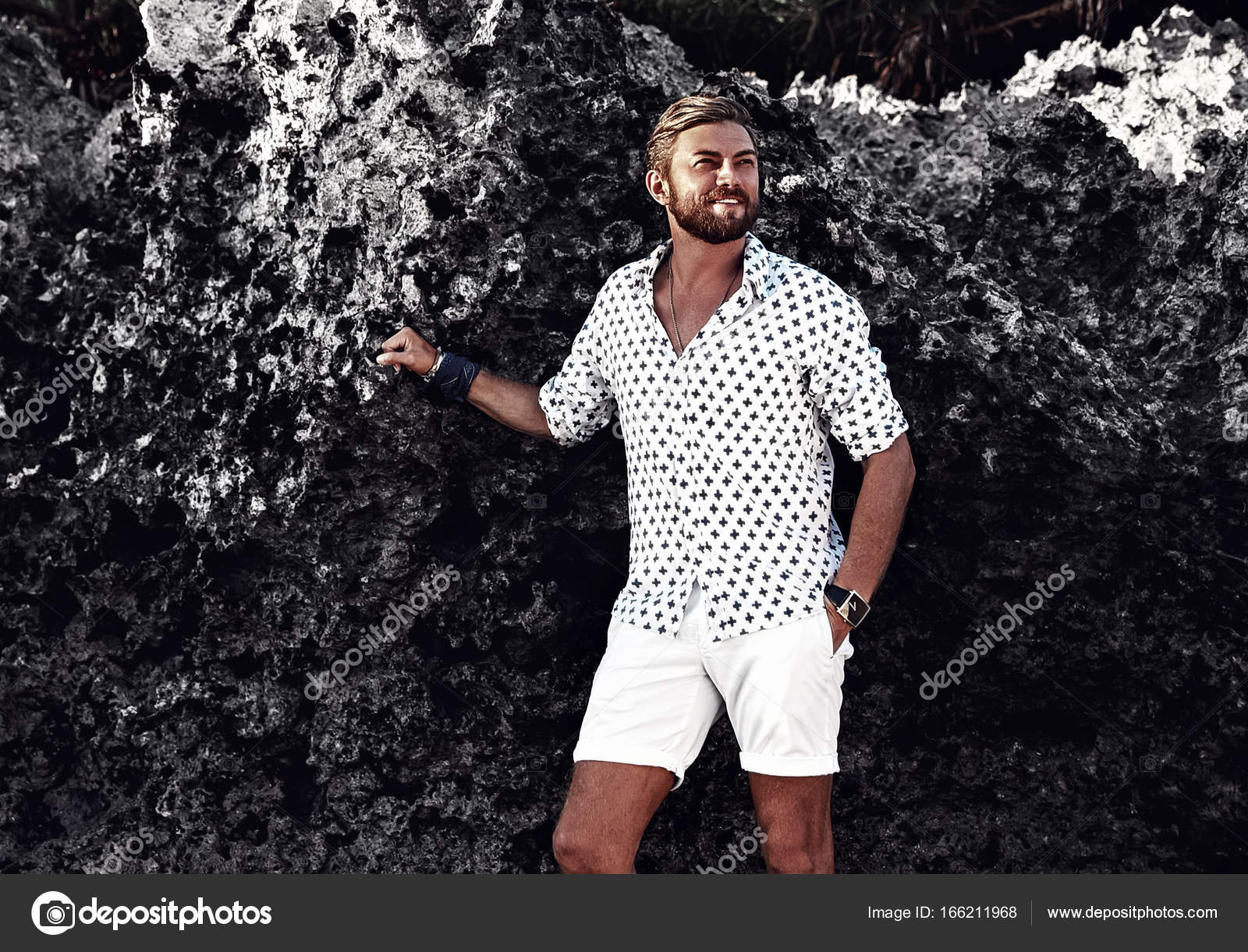 Retrato del guapo modelo de hombre de moda con ropa blanca posando cerca de  las rocas en la playa: fotografía de stock © alexhalay #166211968 |  Depositphotos