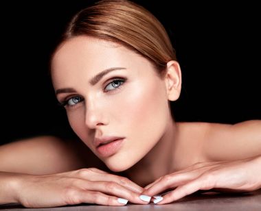 güzel bir kadın modeli hiçbir makyaj ve temiz sağlıklı cilt yüz siyah arka plan üzerine