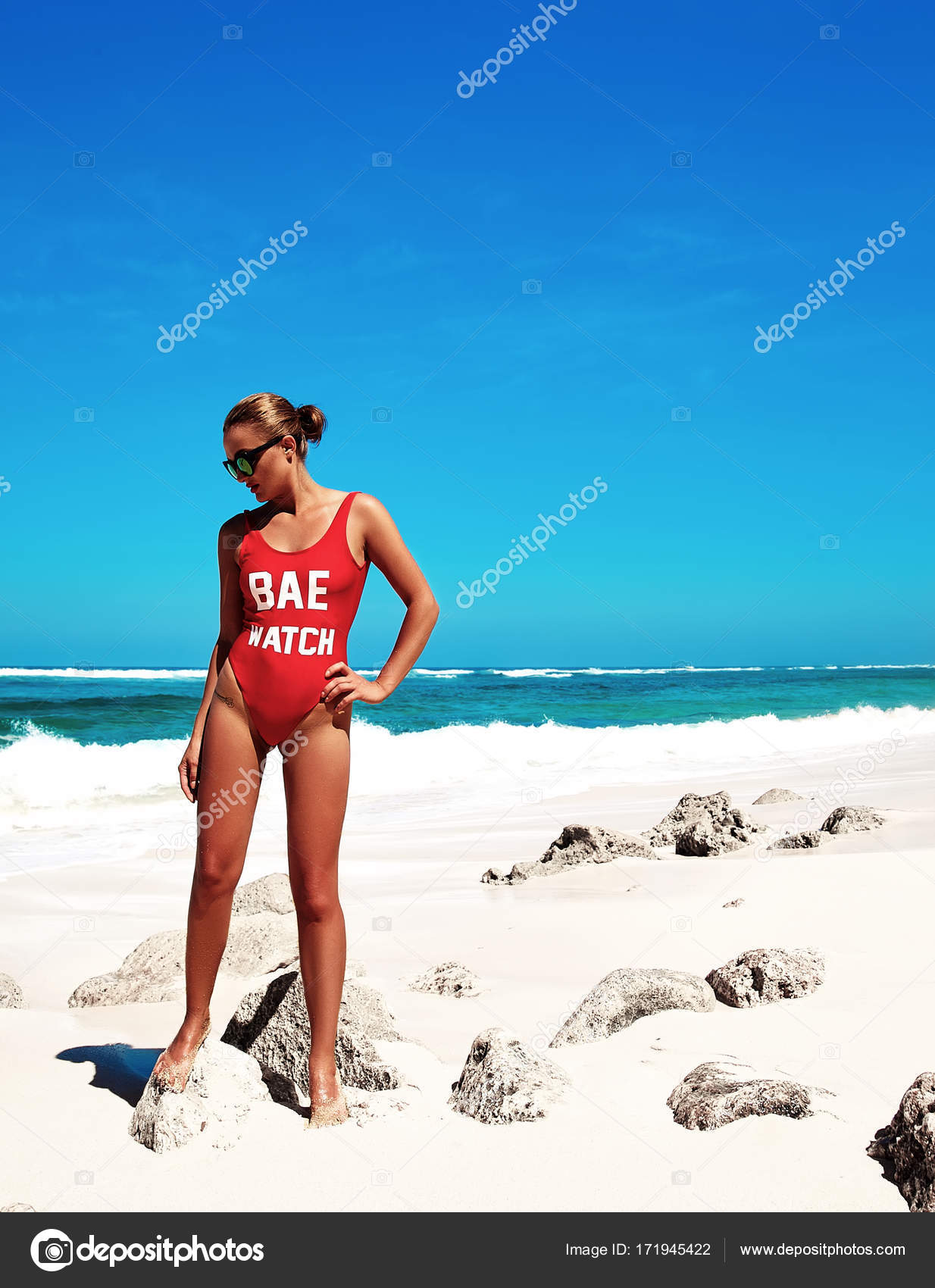 Portrait of beautiful caucasian sunbathed woman model with dark long in  swimsuit posing on summer beach