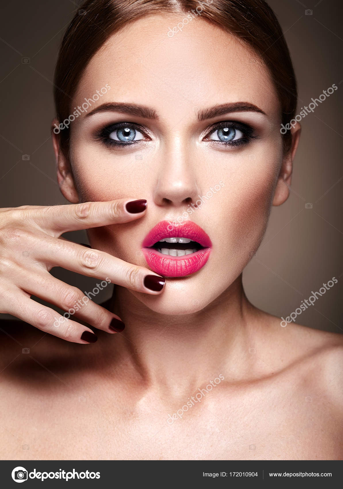 Retrato de uma jovem mulher bonita com noite maquiagem tocando seu