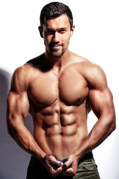 Beyaz üzerinde izole edilmiş güçlü sağlıklı atletik adam fitness modeli portresi