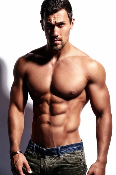 Beyaz üzerinde izole edilmiş güçlü sağlıklı atletik adam fitness modeli portresi