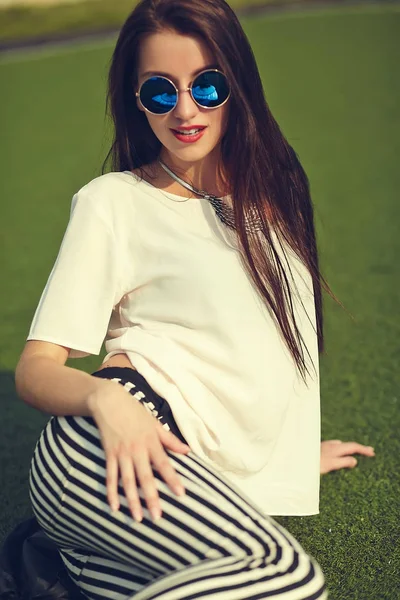 Moda hermosa mujer morena joven modelo en verano hipster ropa casual posando en el fondo de la calle en el parque — Foto de Stock