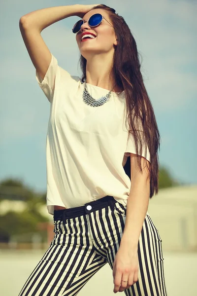 Moda hermosa mujer morena joven modelo en verano hipster ropa casual posando en el fondo de la calle en el parque —  Fotos de Stock