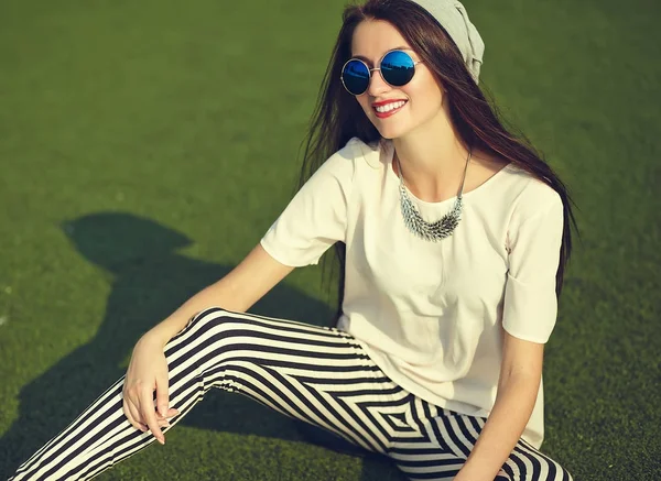 Snygg vacker ung brunett kvinna modell i sommar hipster casual kläder poserar på gatan bakgrund i parken — Stockfoto