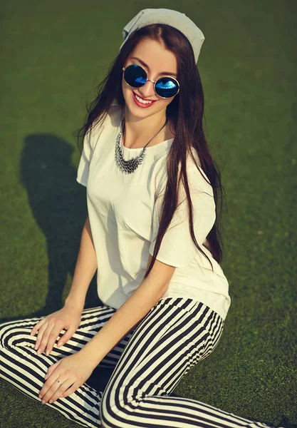 Moda elegante bela jovem morena modelo de mulher no verão hipster roupas casuais posando no fundo da rua no parque — Fotografia de Stock
