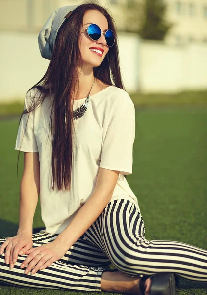 Moda hermosa mujer morena joven modelo en verano hipster ropa casual posando en el fondo de la calle en el parque —  Fotos de Stock