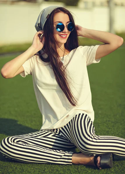 Moda hermosa mujer morena joven modelo en verano hipster ropa casual posando en el fondo de la calle en el parque —  Fotos de Stock