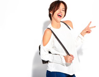 Güzel gülümseyen şirin esmer kadın modeli rahat yaz giysileri üzerinde beyaz izole hiç makyaj ile portresi. Barış işareti gösterilen