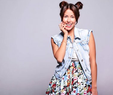 Güzel gülümseyen şirin esmer kadın model gri izole boynuzları saç modeli ile hiç makyaj ile rahat yaz kot pantolon giysili portresi. Parmağını ısırma