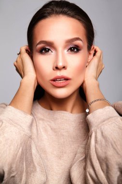 Portre rahat bej sıcak kazak elbise gri izole hiç makyaj ile gülümseyen güzel şirin esmer kadın modeli