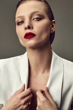 Makyaj ve kırmızı dudakları beyaz ceketli studio arka plan üzerinde poz akşam ile güzel şık esmer kadın manken portresi