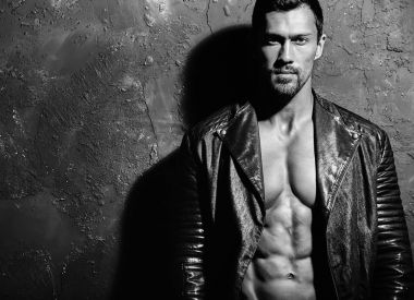 seksi yakışıklı moda erkek model adam portresi Studio gri grunge duvarda poz siyah bisikletçinin deri ceket giymiş. Metroseksüel
